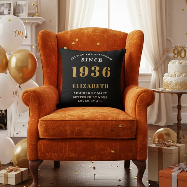 90th Birthday Gift Personalized 1936 Black Gold Cushion (A "Since 1936" pillow on an orange velvet armchair in a 90th birthday decorated room)