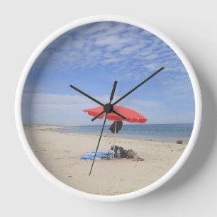 A beach umbrella at the sea. clock