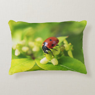 A beautiful shiny ladybug on green leaves decorative cushion