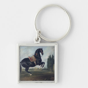 A black horse performing the Courbette Key Ring