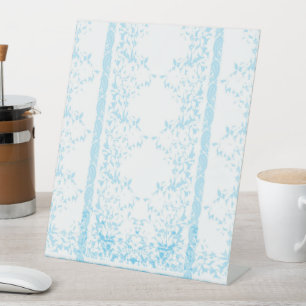 a blue and white striped background with leaves pedestal sign