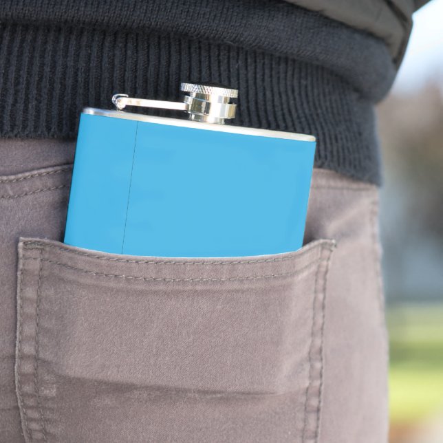 a blue background with a black and white cat hip flask (In Situ)