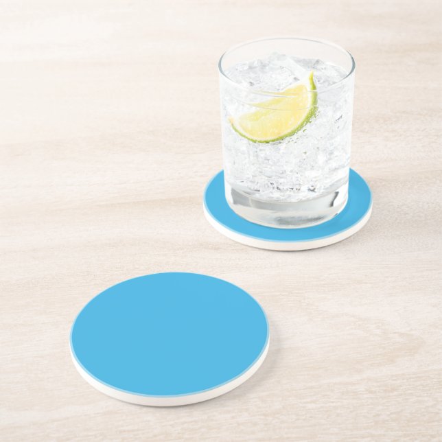 a blue background with a black and white cat on to coaster (Side)