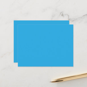 a blue background with a black and white cat postcard