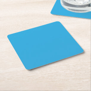 a blue background with a black and white cat square paper coaster