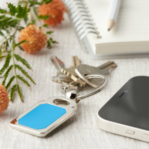 a blue sky with a plane flying in the sky key ring