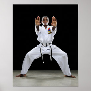 A Boy (15 Years Old) in a Karate Uniform with Poster
