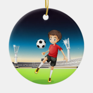 A boy playing soccer alone ceramic tree decoration