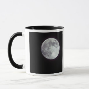 A bright full moon in a black night sky. mug