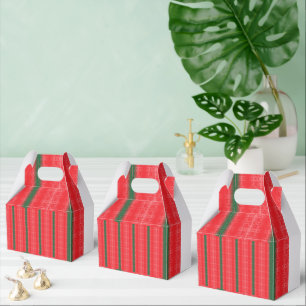 A bright red apple sits on a plain white surface. favour box