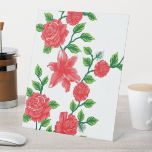 a bunch of red flowers on a white background pedestal sign