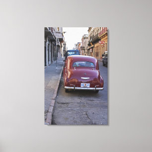 A classic old red Peugeot car parked on a street Canvas Print