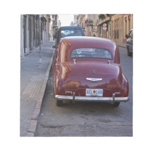 A classic old red Peugeot car parked on a street Notepad