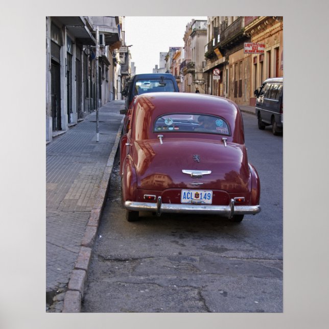 A classic old red Peugeot car parked on a street Poster (Front)