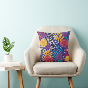 a colourful flower and leaves pattern on a blue ba cushion