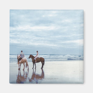 A couple riding horses on Parkiri beach in New Magnet