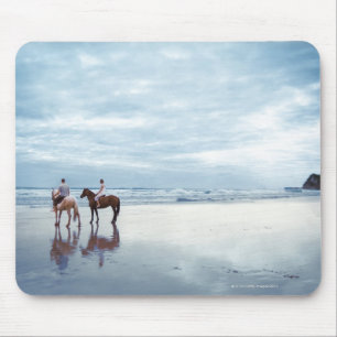 A couple riding horses on Parkiri beach in New Mouse Mat
