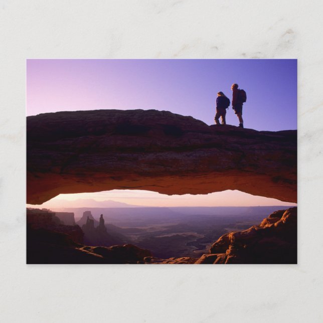 A couple watches sunrise from atop Mesa Arch in Postcard (Front)