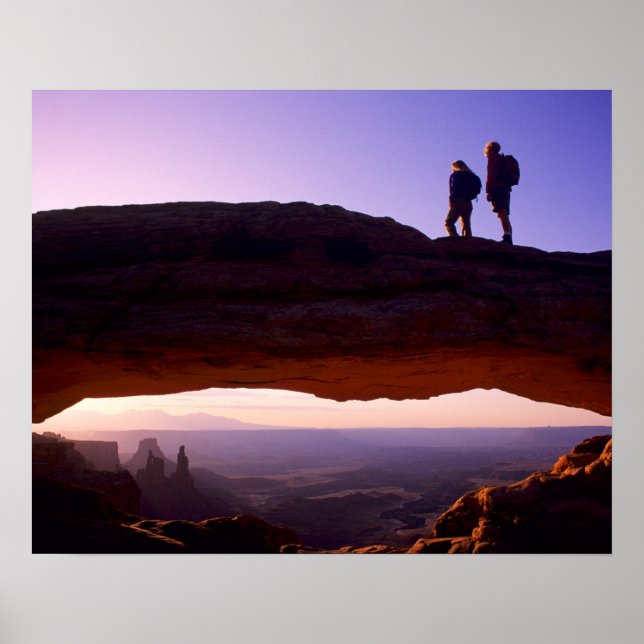 A couple watches sunrise from atop Mesa Arch in Poster (Front)