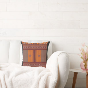 a cross stitch pattern in orange and brown cushion