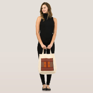a cross stitch pattern in orange and brown tote bag