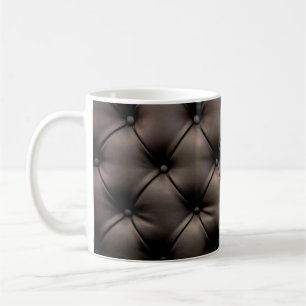 A dark leather cushion background, from a car seat coffee mug