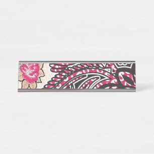 A decorative paisley design with vivid red and pin desk name plate
