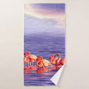 A flock of beautiful pink flamingos against a purp bath towel