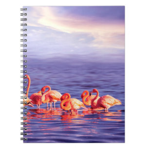 A flock of beautiful pink flamingos against a purp notebook