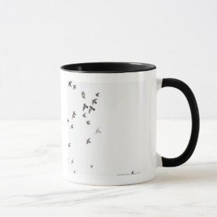A flock of birds is flying at the sky mug