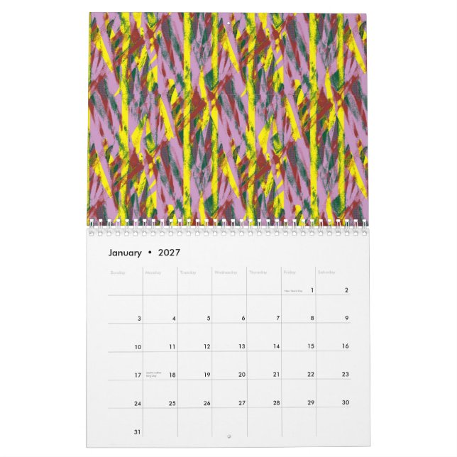 A fluffy grey cat with green eyes sits on a window calendar (Jan 2027)