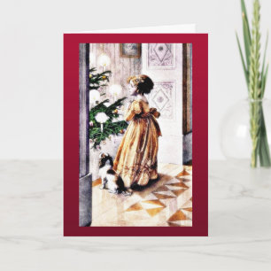 A girl with a dog praying infront of christmas tre holiday card