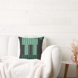 a green and black pattern with a tree in the middl cushion