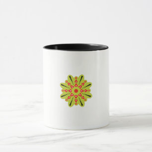 a green and red flower with black dots mug