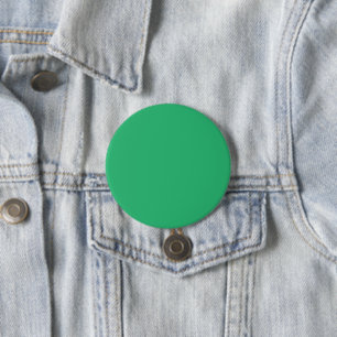 a green background with a white border 7.5 cm round badge