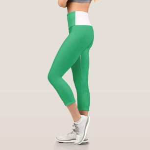 a green background with a white border capri leggings