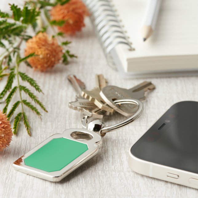 a green background with a white border key ring (Side)