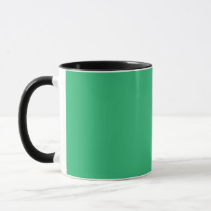 a green background with a white border mug