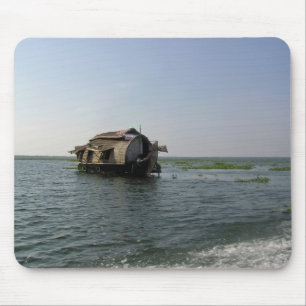 A houseboat moving placidly through a coastal lake mouse mat