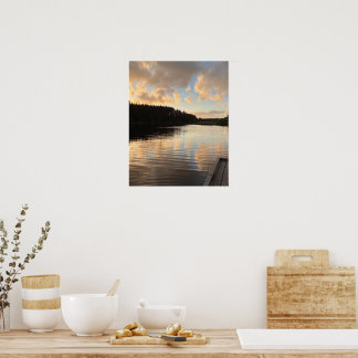 A lake at sunset mirroring the sky poster