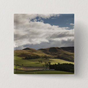 A Landscape With Rolling Hills And Clouds Overhead 15 Cm Square Badge