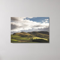 A Landscape With Rolling Hills And Clouds Overhead