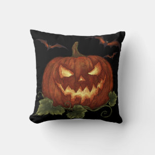 A large pumpkin with glowing eyes and bats cushion