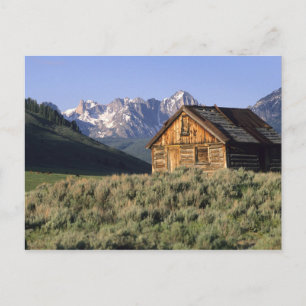 A log cabin and the Sawtooth Mountains in Postcard