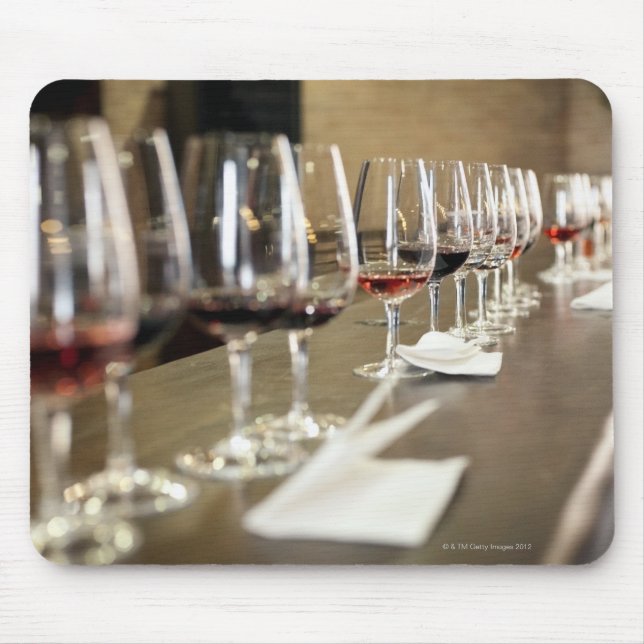 A long row of wine glasses set up so a large mouse mat (Front)