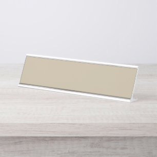 a man in a suit and tie standing in front of a wal desk name plate