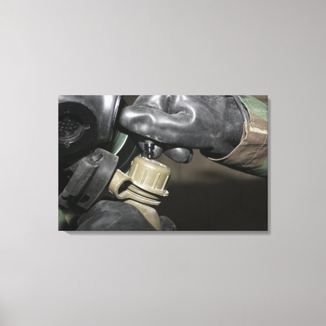 A Marine inserts a drinking tube into his cante Canvas Print (Front)