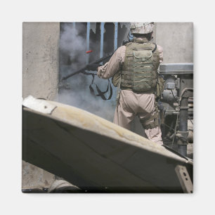 A military policeman uses a breaching round magnet