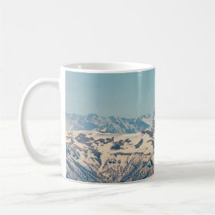 A mountain range with thawing snow and ice in the coffee mug