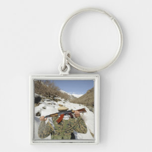 A Mujahadeen Guard walks with US Military membe Key Ring